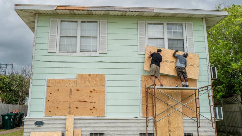 People installing plywood on their home before Hurricane Beryl made landfall.